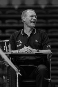 Picture of a smiling Richard Bramley umpiring a badminton event